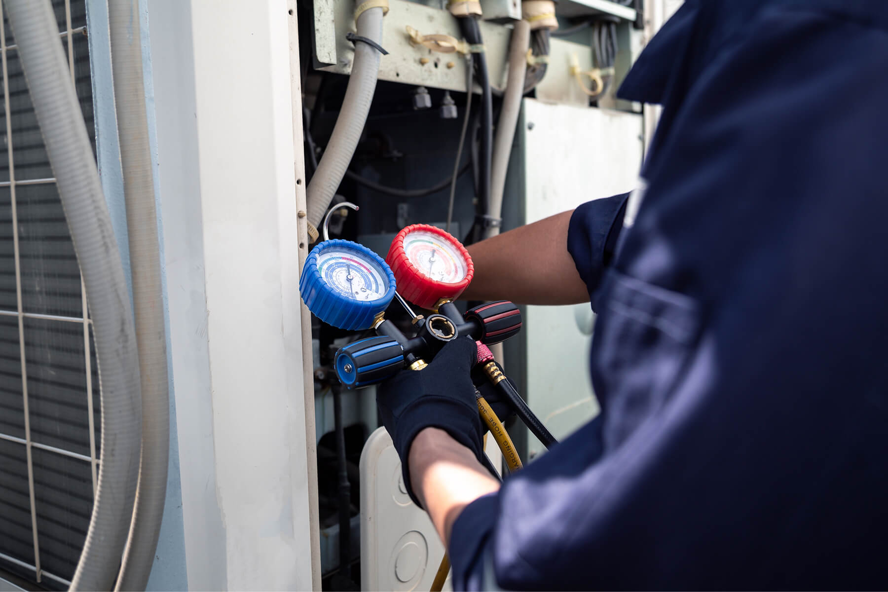 Shutterstock 2665631485 min | ares diesel repair Hvac Technician Uses a Manifold Gauge Set blue and Red Gauges to Test Refrigerant Pressure on an Air Conditioning Unit Gloved Hands Visible in the Frame